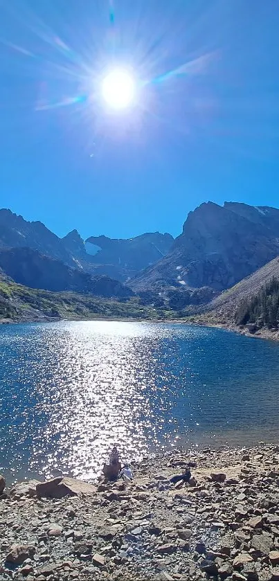 Serene mountain lake with clear blue sky and rocky shore.