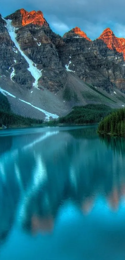 Serene mountain lake with blue water and rocky peaks at sunset.