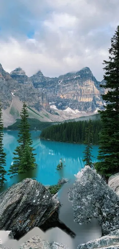 Majestic mountain lake surrounded by forest and rocky peaks under a cloudy sky.