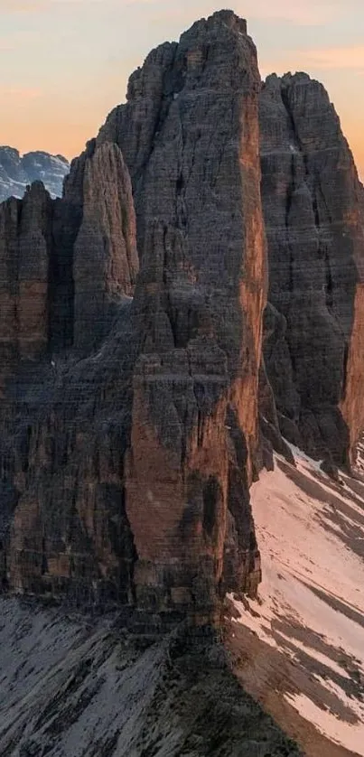 Mountain peaks at sunrise with a serene sky.