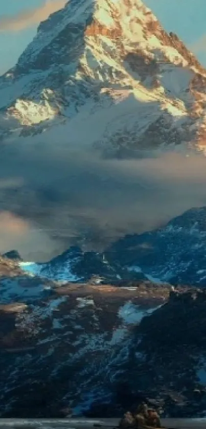 Majestic snow-capped mountain peak surrounded by clouds with blue sky.