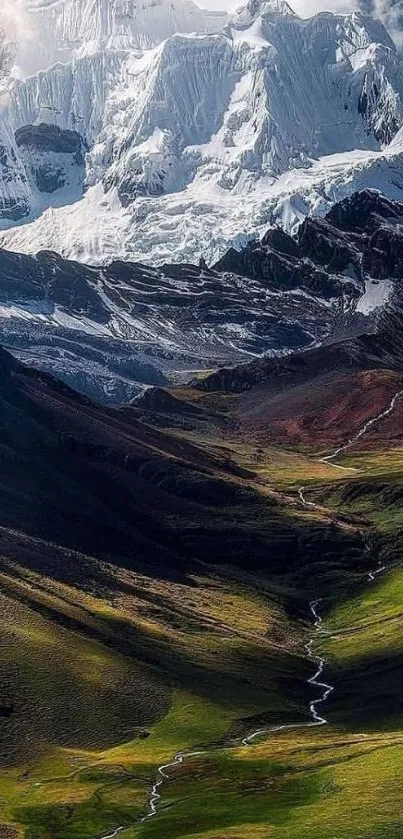 Breathtaking snow-capped mountain with lush green valley and winding stream.