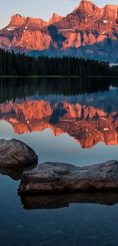 Majestic mountain reflected in calm lake with orange hues.