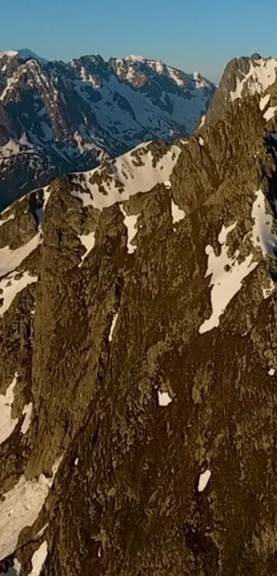 Mobile wallpaper of a rugged mountain ridge with snow.