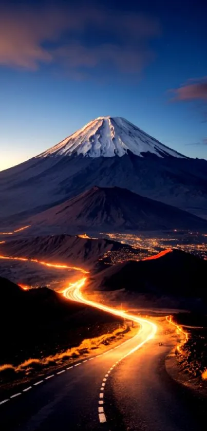 Snow-capped mountain with road lights at dusk, featuring a vivid sky.