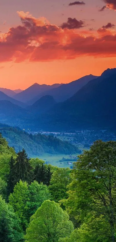 Vibrant sunset over mountain landscape with lush green forest.