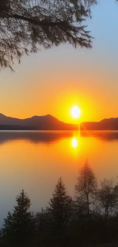 Mountain sunset over lake with orange glow and reflections.