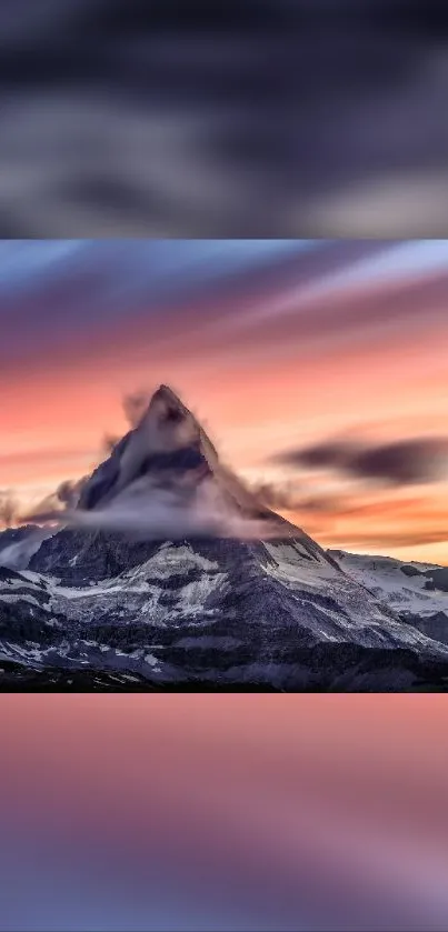 Mountain peak at sunset with colorful sky hues.