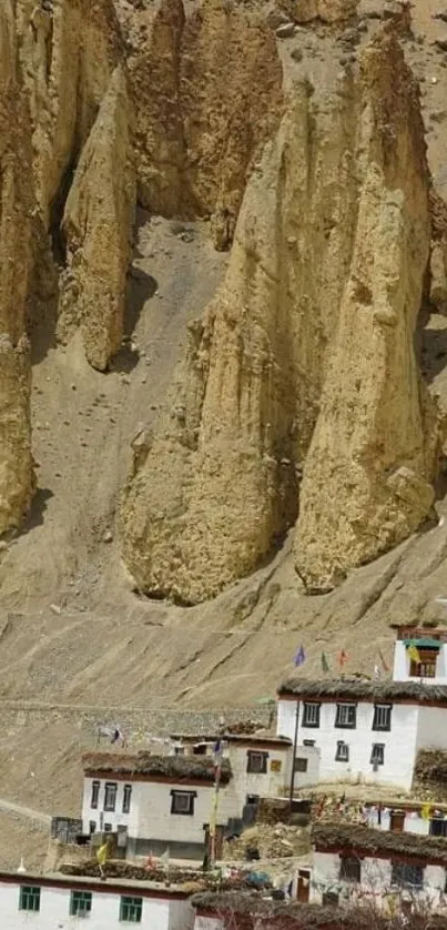 Mountain village with rugged cliffs in background.