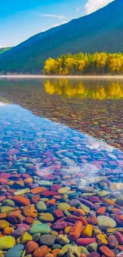 Vibrant mountain lake with pebbles and autumn trees under a blue sky.