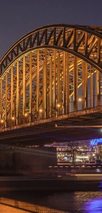 Illuminated bridge at night with water reflection.