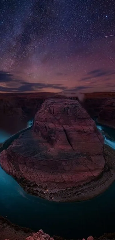 Canyon at night with a star-filled sky and vivid twilight colors.