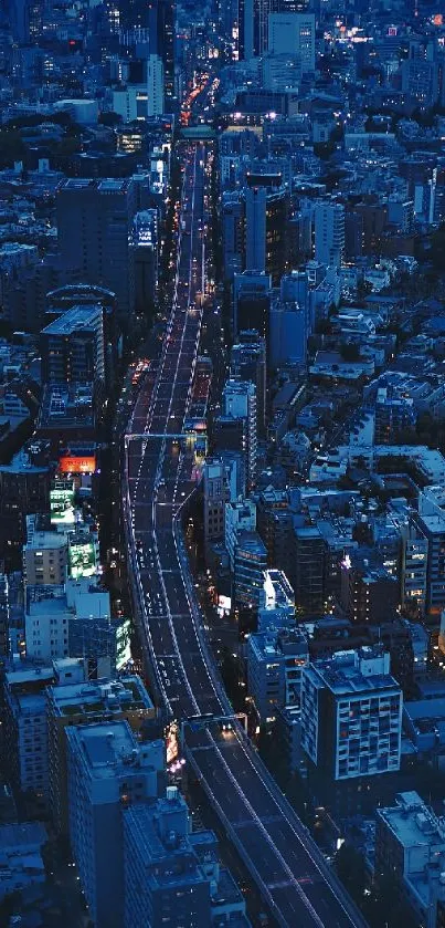 Aerial night view of a cityscape with illuminated streets and vibrant blue skyline.