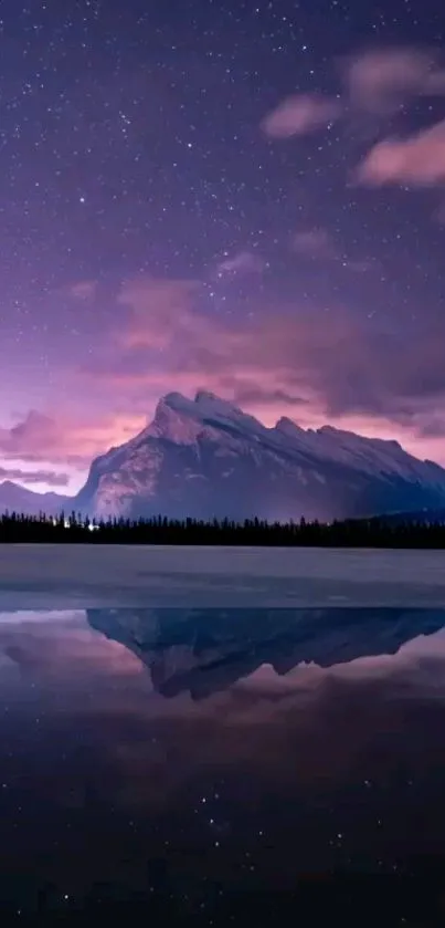 Majestic mountain under a starry night sky reflected in a tranquil lake.