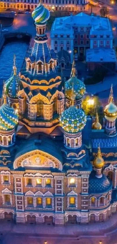 Aerial view of an illuminated cathedral at night with vibrant city lights.