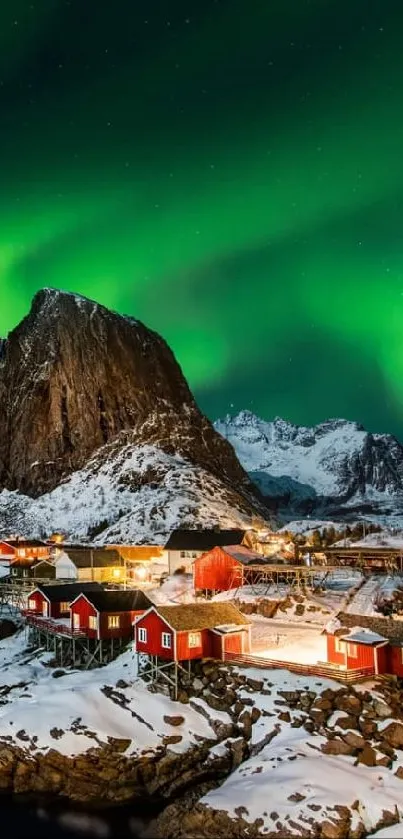 Northern Lights over snowy Norwegian village and mountains at night.