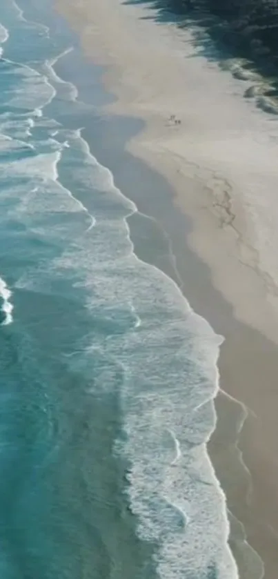 Aerial view of serene beach with ocean waves and sandy shoreline.