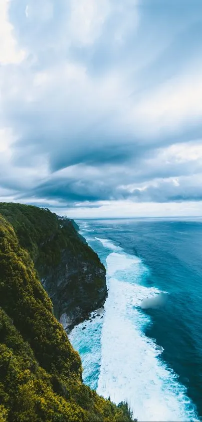 Stunning ocean cliff view with vibrant blue waters and a moody sky.