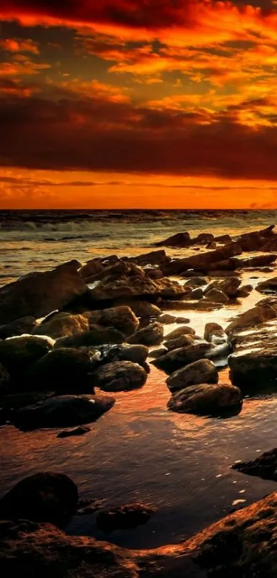 Fiery ocean sunset over rocky shores wallpaper.