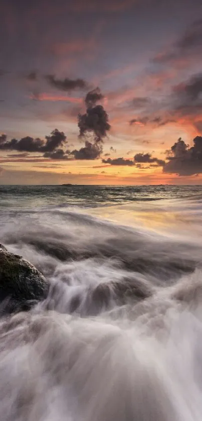 Breathtaking sunset over ocean with crashing waves and colorful sky.