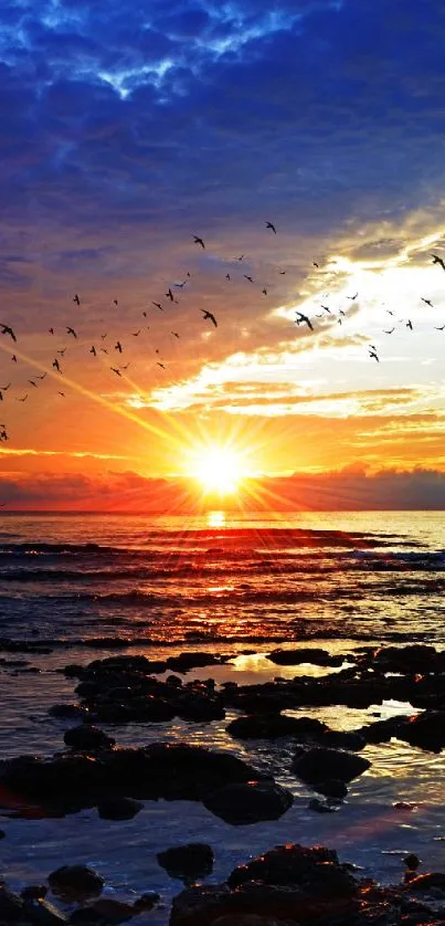 Ocean sunset with vibrant colors and rocky shoreline.