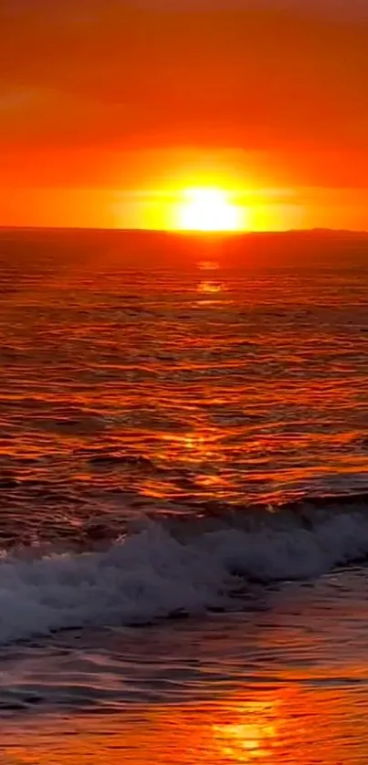 Vibrant orange ocean sunset with waves gently crashing.