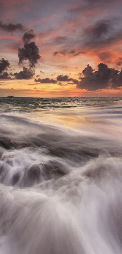 Vibrant ocean sunset with waves and rocks under a colorful sky.