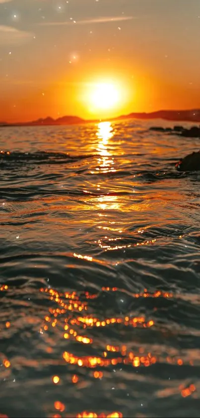 Sunset over ocean with golden reflections and glowing horizon.