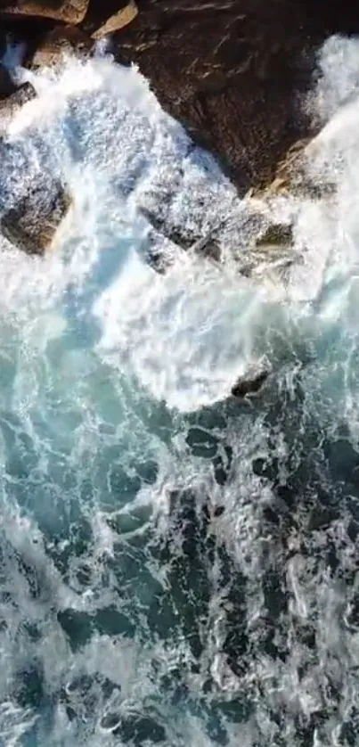 Aerial view of crashing ocean waves against the rocky coastline, showcasing nature's beauty.