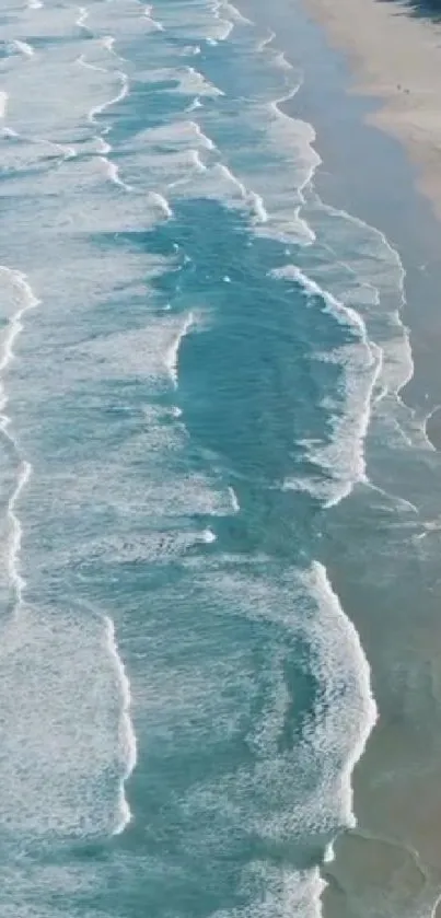 Aerial view of tranquil blue ocean waves on a sandy beach.