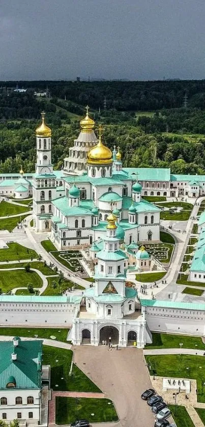 Aerial view of historic cathedral with golden domes amid lush greenery.