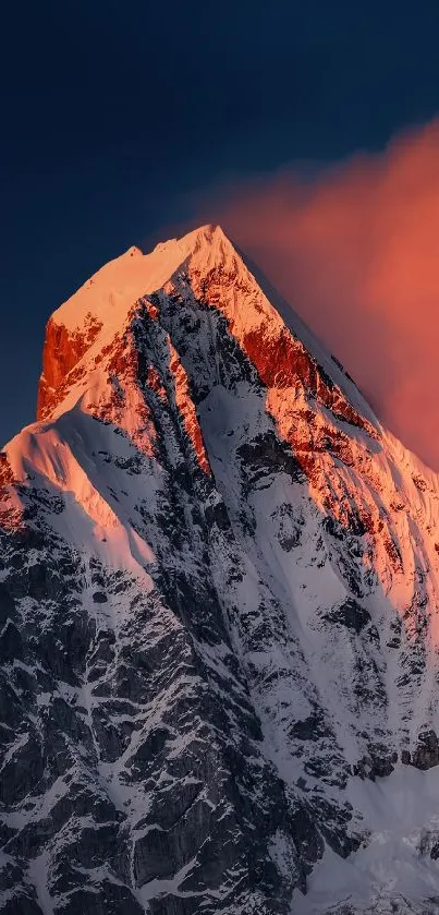 Mountain peak at sunset with pink hues and blue sky backdrop.