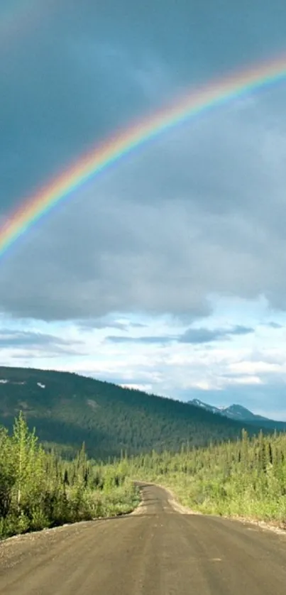 A vibrant rainbow arches over a scenic landscape with a tranquil road.