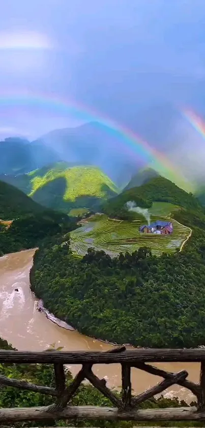 Rainbow arches over lush green mountains and winding river.