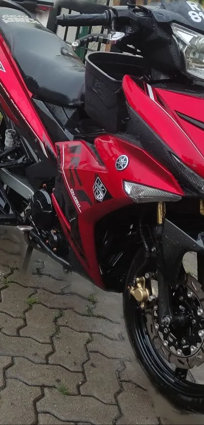 Red motorcycle with sleek sporty design on pavement.