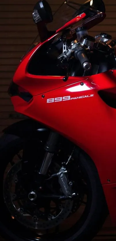 Red sport motorcycle against dark backdrop, sleek design.