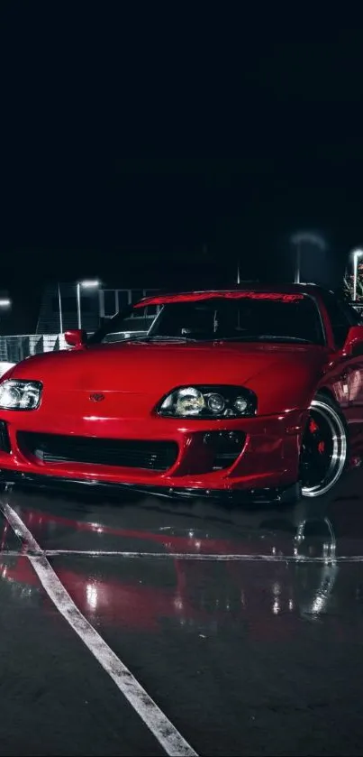 Red sports car in urban night setting with reflections.