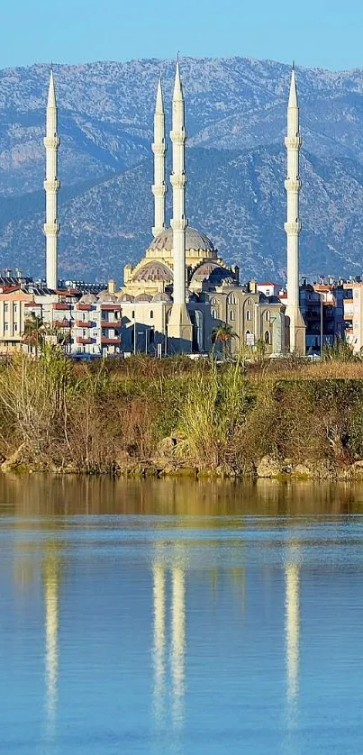 Scenic cityscape with river reflection and mountain background.