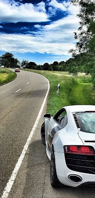 Sleek sports car on a winding road with blue sky.