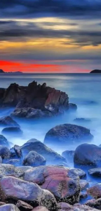 Beautiful sunset over a rocky beach with vibrant sky and serene ocean.