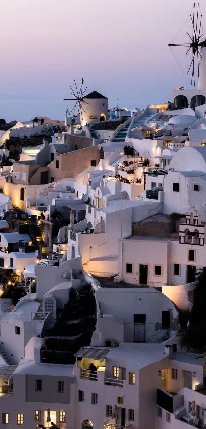 Santorini buildings and windmills at dusk, showcasing a stunning evening view.