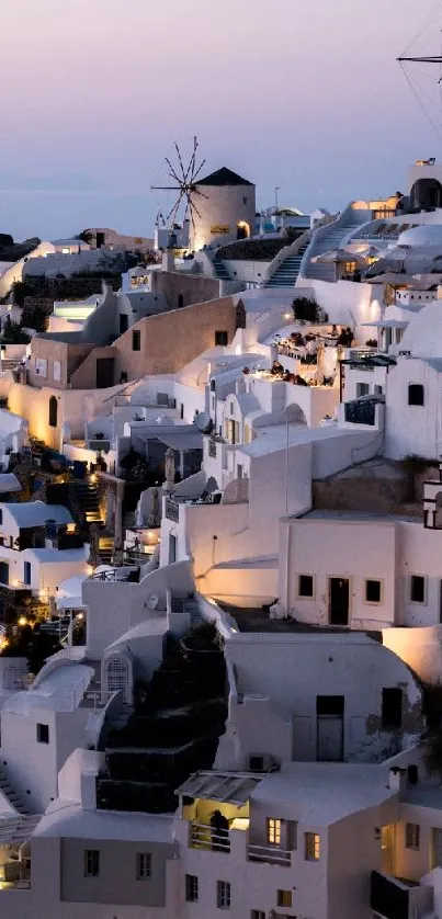 Iconic Santorini view at dusk with white buildings and a peach sky.