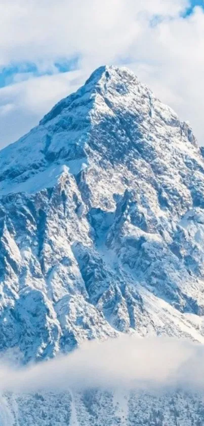 Snow-covered mountain peak with blue sky and clouds.