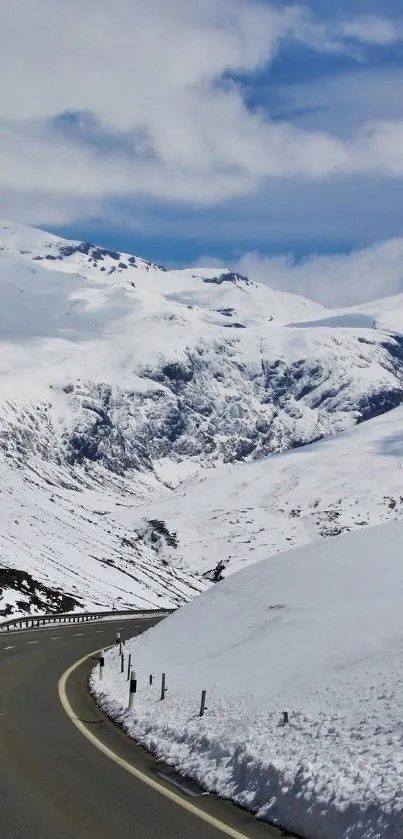 Serene snowy mountain road under a bright blue sky.