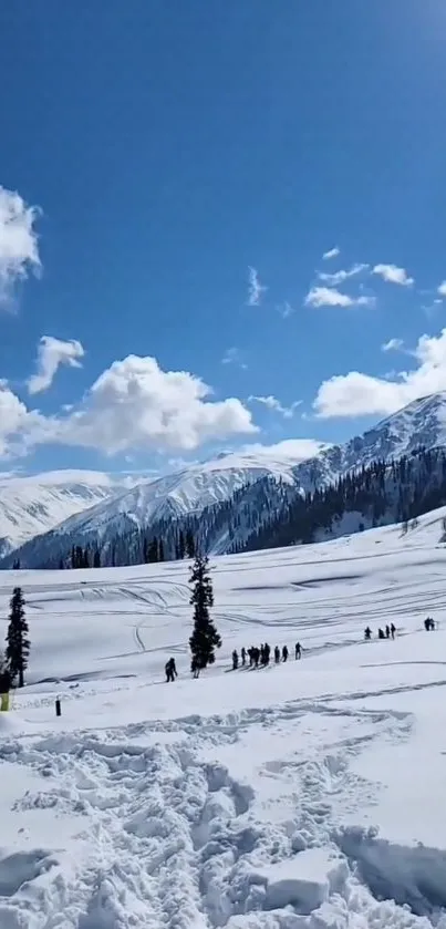 Snowy mountain landscape with a bright blue sky and scattered clouds.