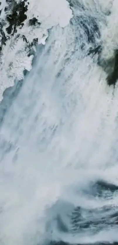 Aerial view of snowy waterfall cascading down cliffs.