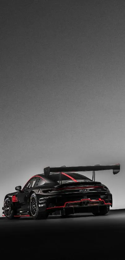 Black sports car with red accents on a gray background, sleek and aerodynamic.