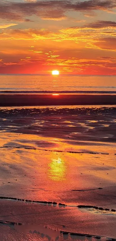 Beautiful orange sunset over a tranquil beach reflecting on calm ocean waves.