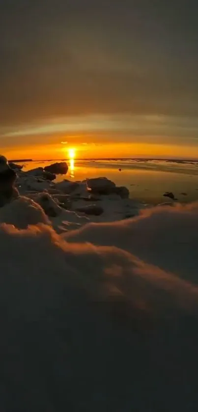 A stunning sunset over a snowy beach with vibrant orange hues and serene waters.