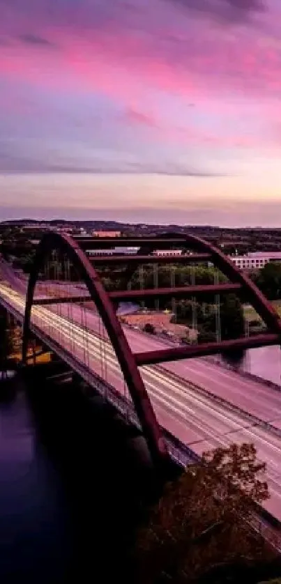 A picturesque bridge at sunset with vibrant skies reflecting on calm water.